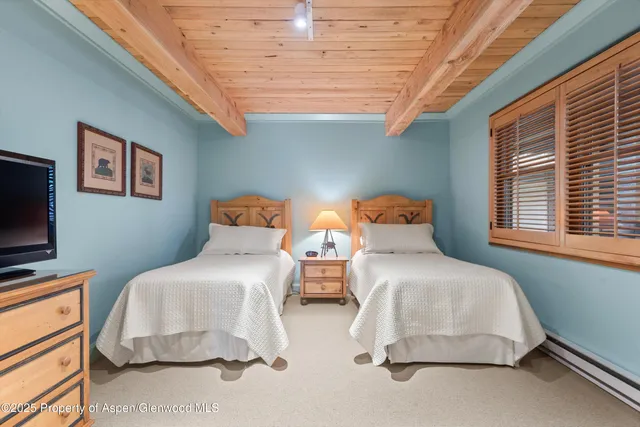 a bedroom with two beds and a window