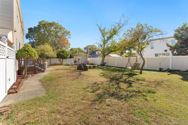 a view of a patio with table and chairs and potted plants with wooden fence