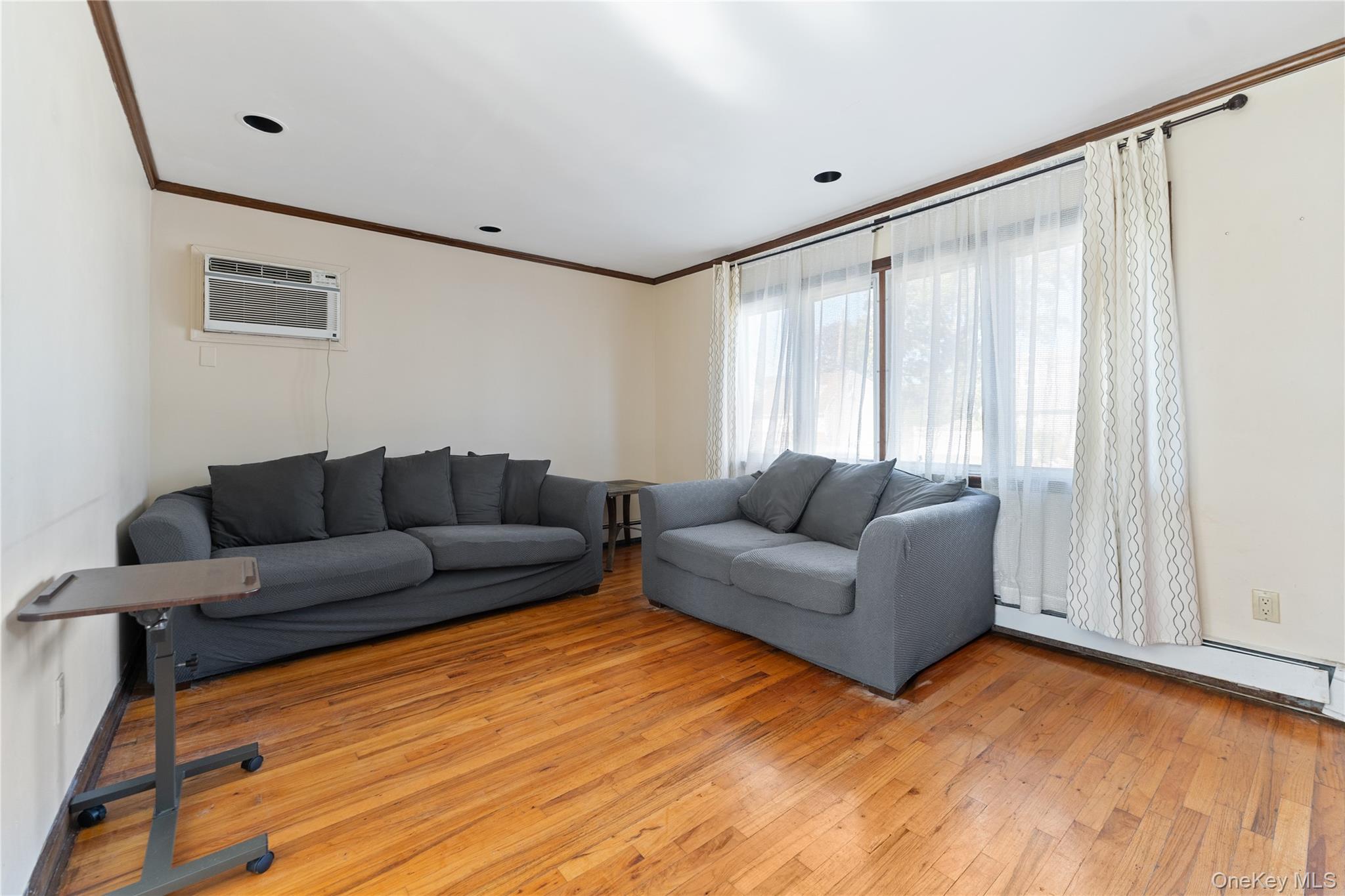 90 27th Street Copiague, NY 11726 - Photo 2 of 18 a living room with furniture and a large window