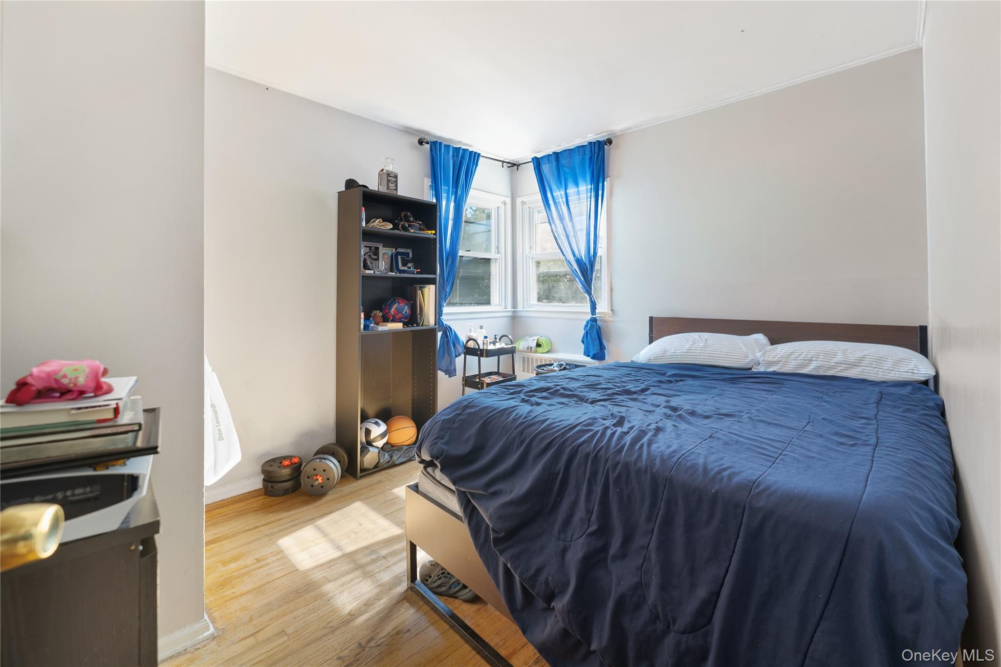 90 27th Street Copiague, NY 11726 - Photo 6 of 18 a bedroom with a bed and a wooden floor