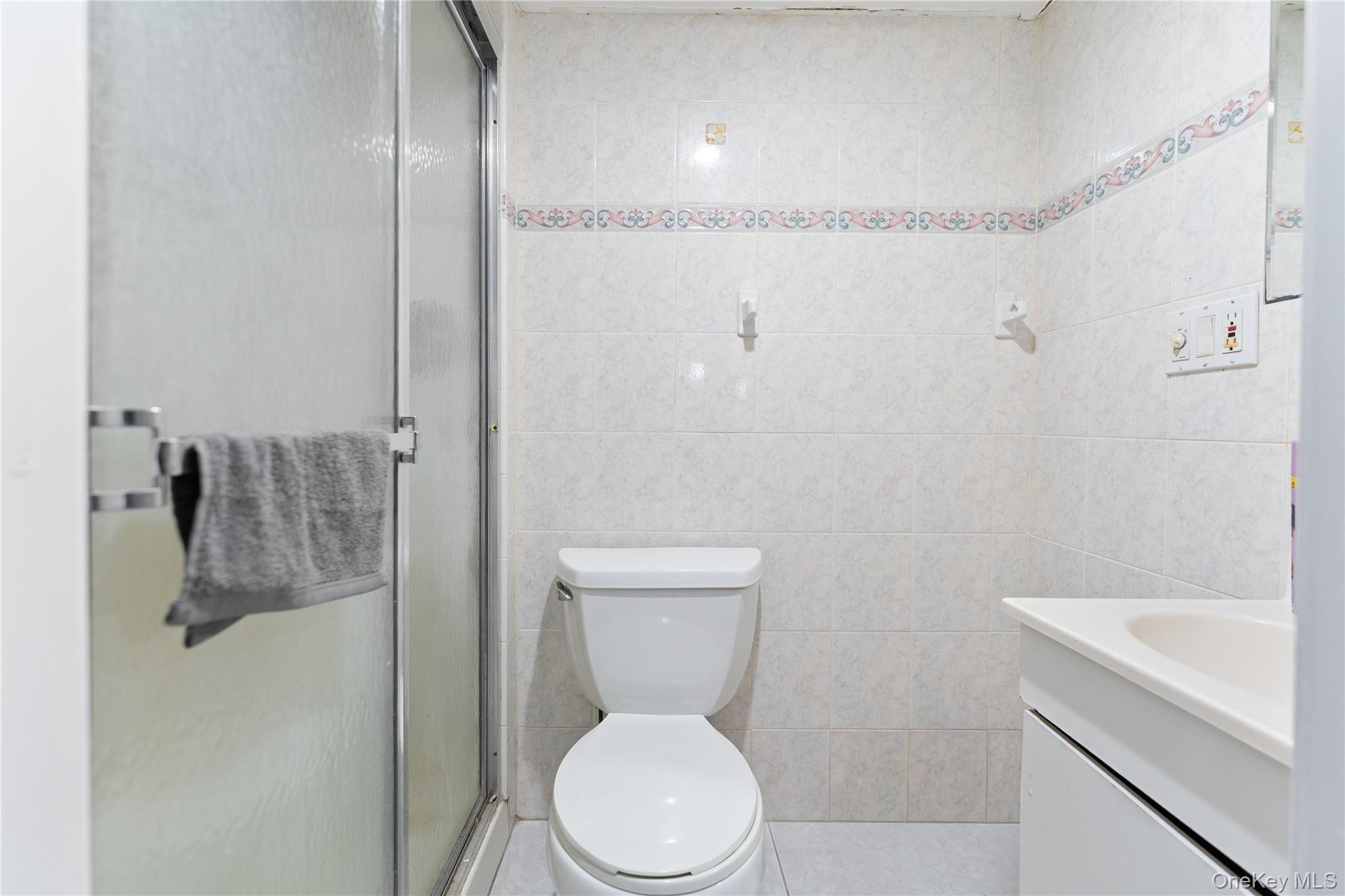 90 27th Street Copiague, NY 11726 - Photo 9 of 18 a white toilet sitting next to a bathroom sink