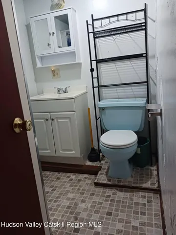 a bathroom with a granite countertop toilet and a sink