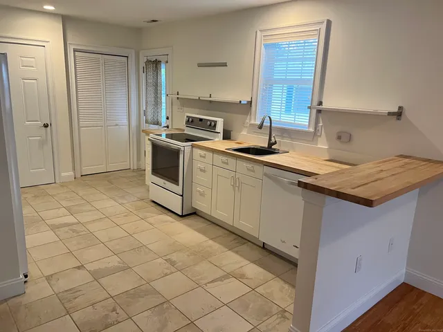 a kitchen with a sink a stove and cabinets