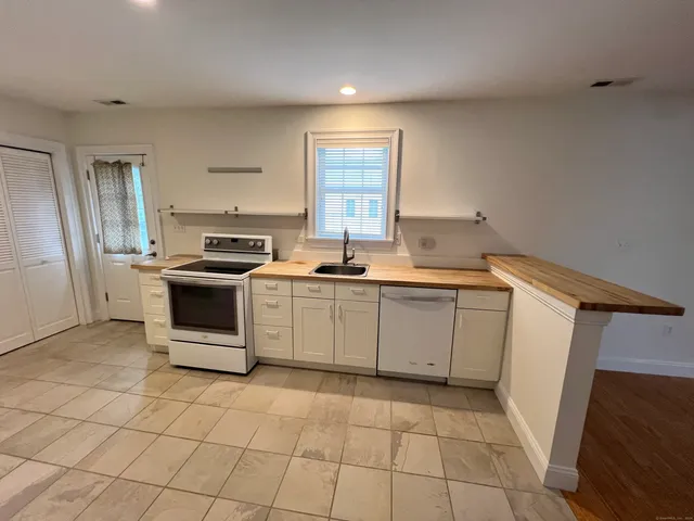 a view of a kitchen with a sink and refrigerator