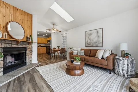 a living room with furniture a fireplace and wooden floor