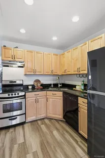 a kitchen with stainless steel appliances granite countertop a stove a sink and a refrigerator
