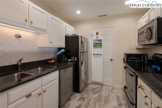 a kitchen with stainless steel appliances a sink stove and refrigerator