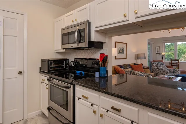 a kitchen with stainless steel appliances granite countertop a sink stove and microwave