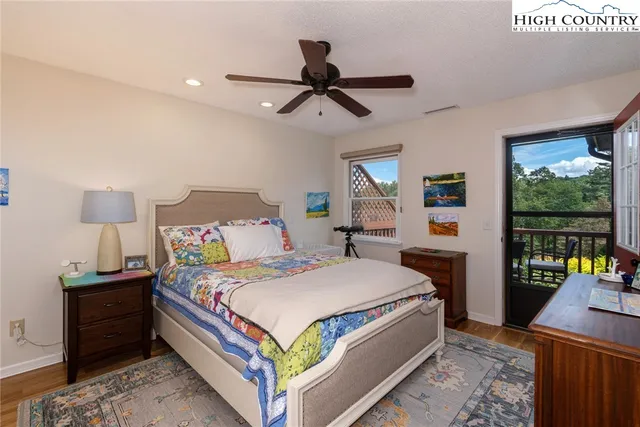 a bedroom with a bed and large windows