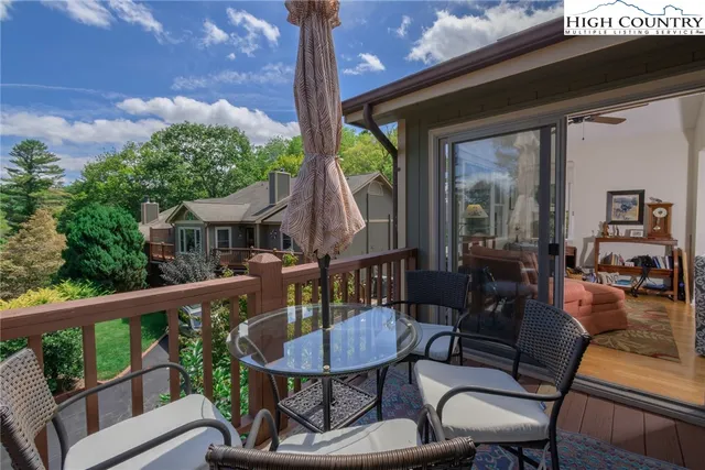 a view of a patio with table and chairs with wooden floor and fence