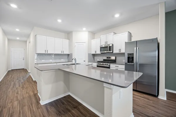a kitchen with stainless steel appliances granite countertop a sink stove and refrigerator