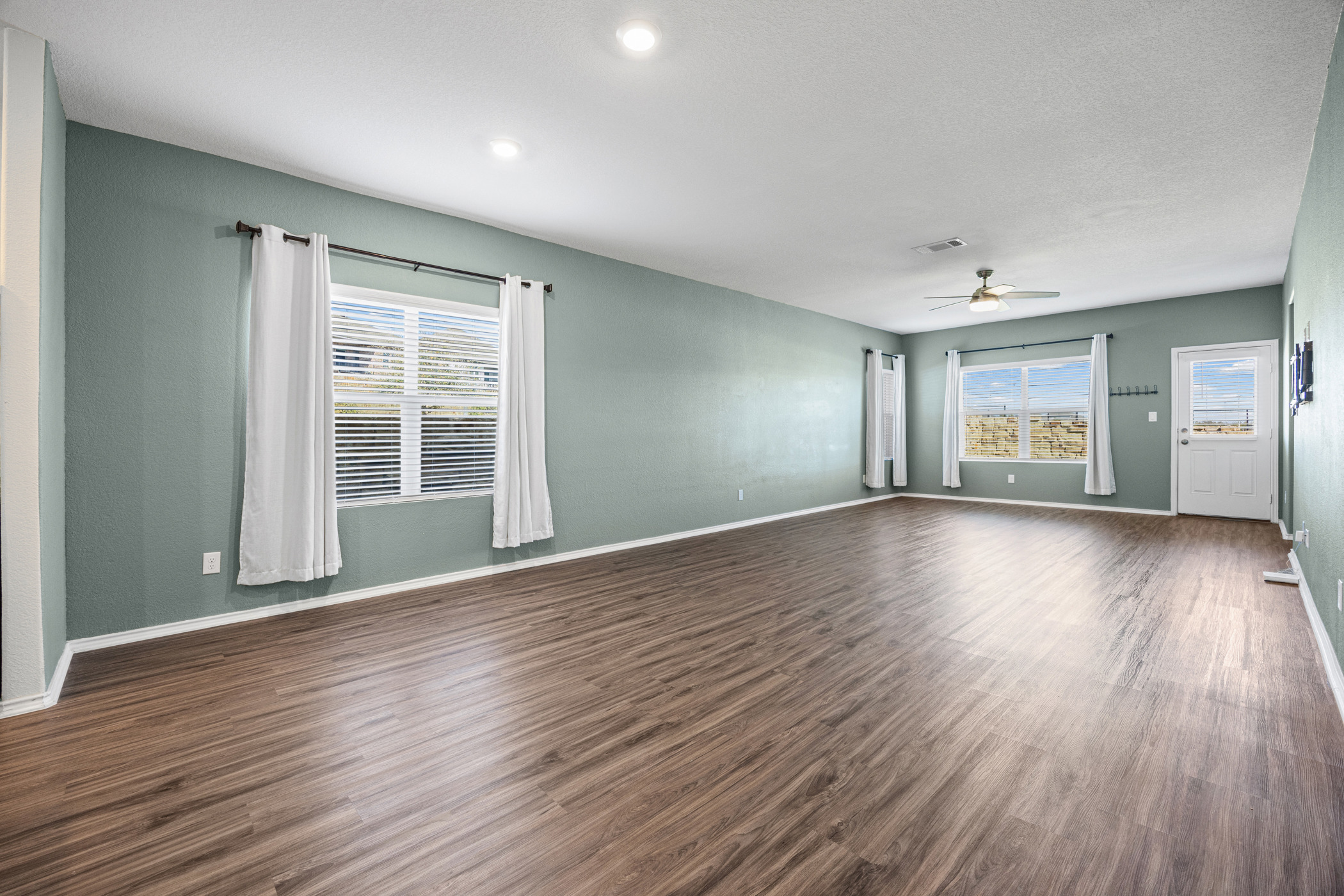 1609 Woolsey Way Leander, TX 78641 - Photo 8 of 29 a view of an empty room with wooden floor and windows