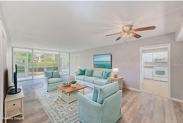 10280 Imperial Point Drive West, Unit 7 Largo, FL 33774 - Photo 21 of 67 a living room with furniture a table and a large window