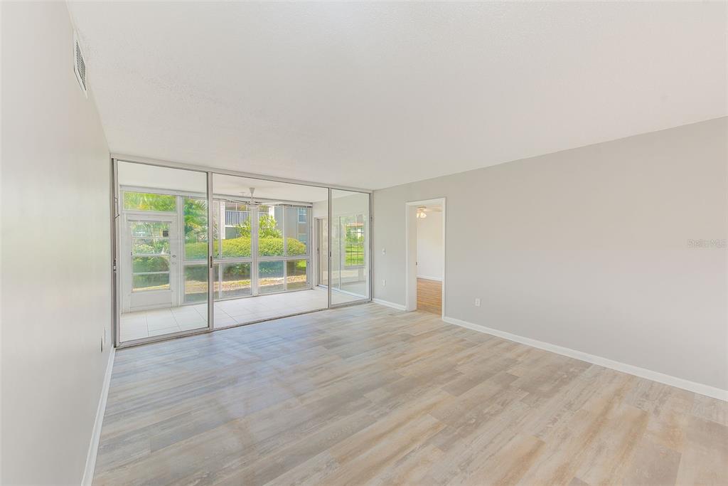 10280 Imperial Point Drive West, Unit 7 Largo, FL 33774 - Photo 22 of 67 an empty room with wooden floor and windows