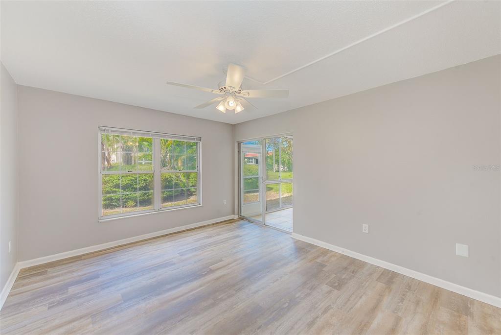 10280 Imperial Point Drive West, Unit 7 Largo, FL 33774 - Photo 24 of 67 an empty room with wooden floor and windows