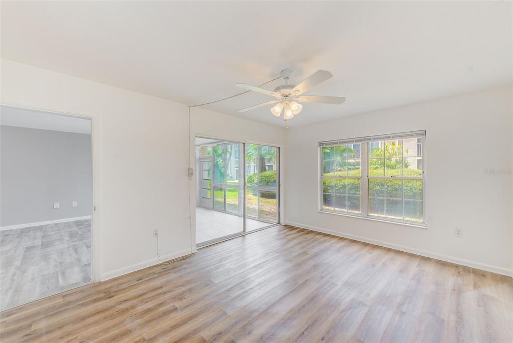 10280 Imperial Point Drive West, Unit 7 Largo, FL 33774 - Photo 31 of 67 an empty room with wooden floor and windows