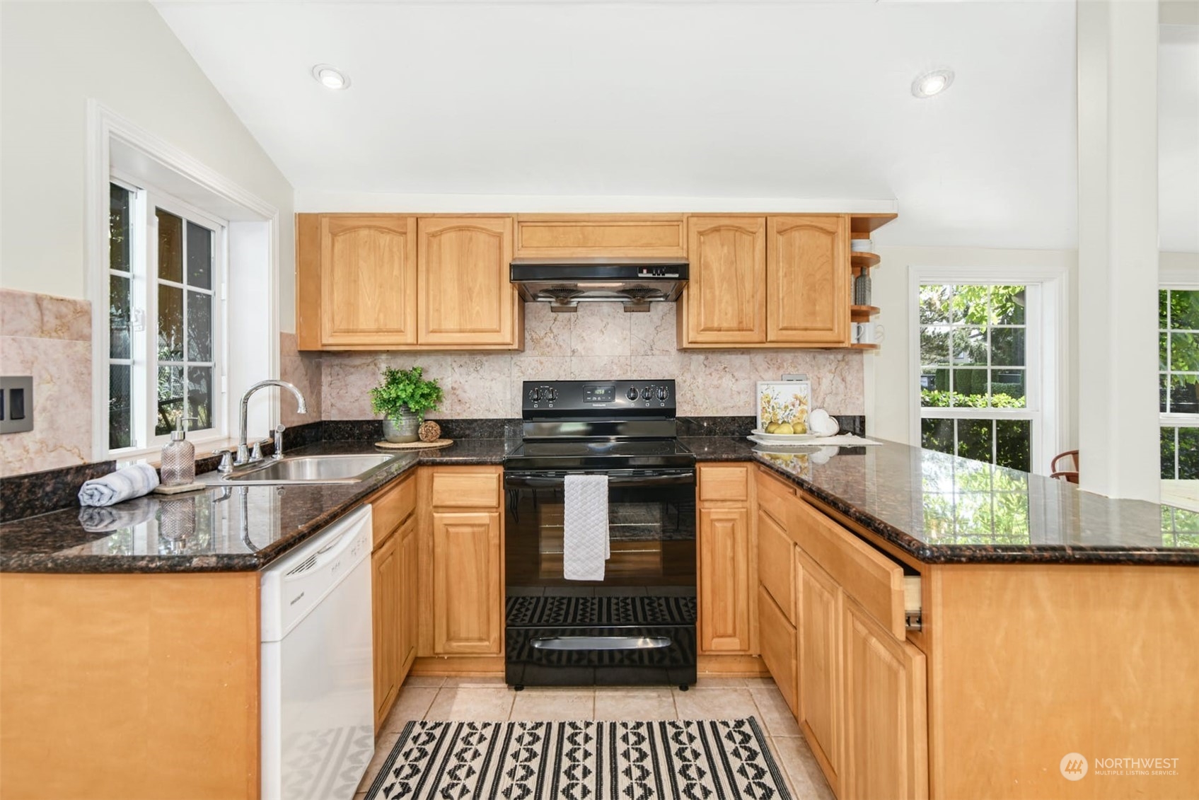 469 Maple Avenue Southwest Renton, WA 98057 - Photo 6 of 30 a kitchen with granite countertop a sink stove and cabinets