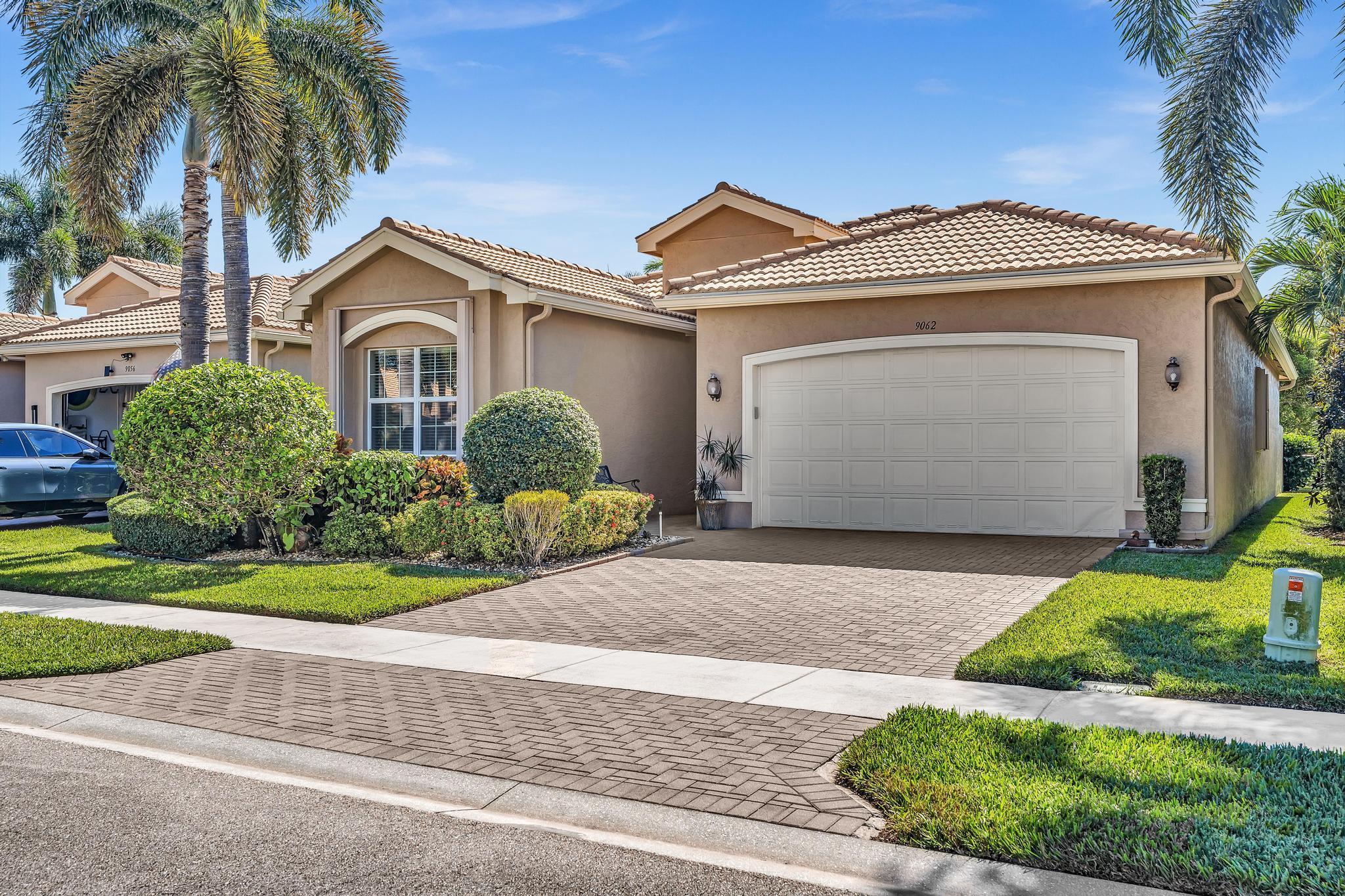 9062 Meridian View Isle Boynton Beach, FL 33473 - Photo 2 of 71 a front view of a house with a garden and entryway