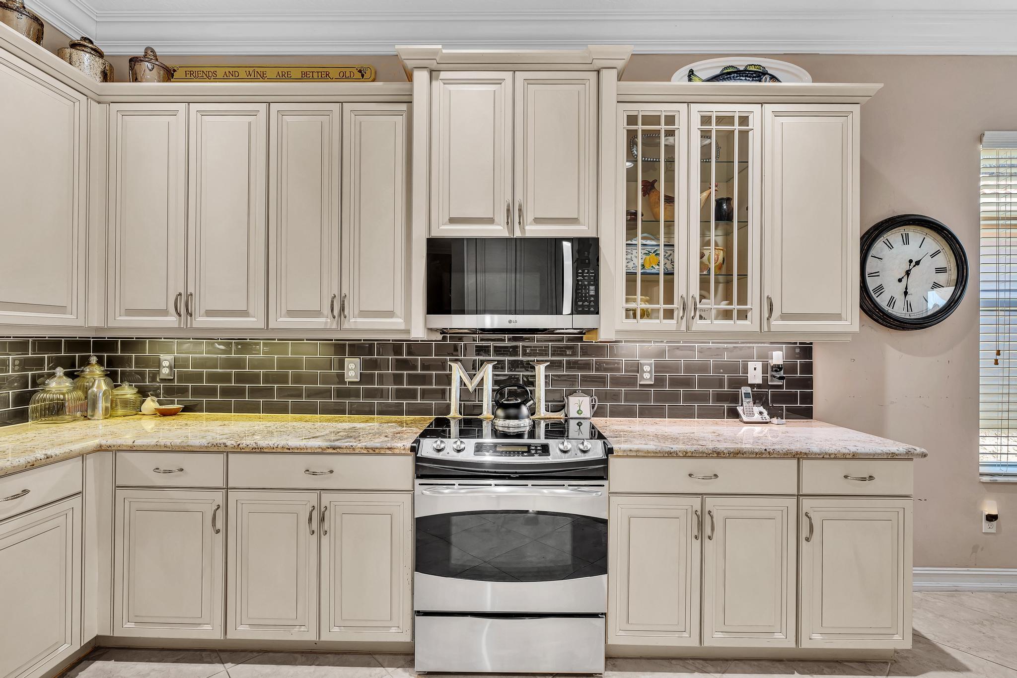 9062 Meridian View Isle Boynton Beach, FL 33473 - Photo 23 of 71 a kitchen with stainless steel appliances granite countertop a sink a stove a microwave and cabinets