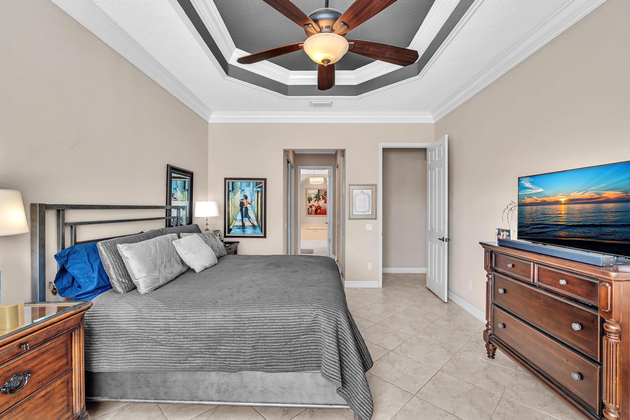 9062 Meridian View Isle Boynton Beach, FL 33473 - Photo 48 of 71 a bedroom with a bed and a chandelier