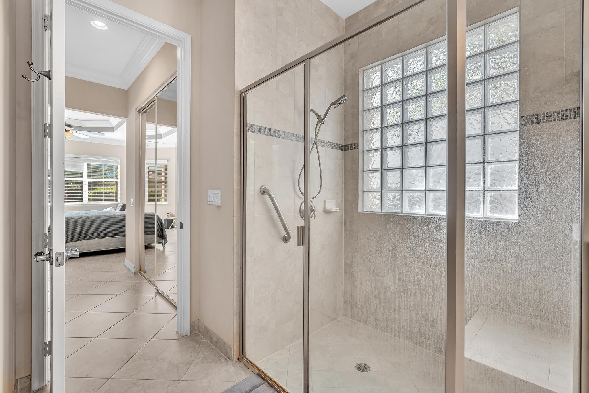 9062 Meridian View Isle Boynton Beach, FL 33473 - Photo 52 of 71 a bathroom with a glass shower door and a glass door