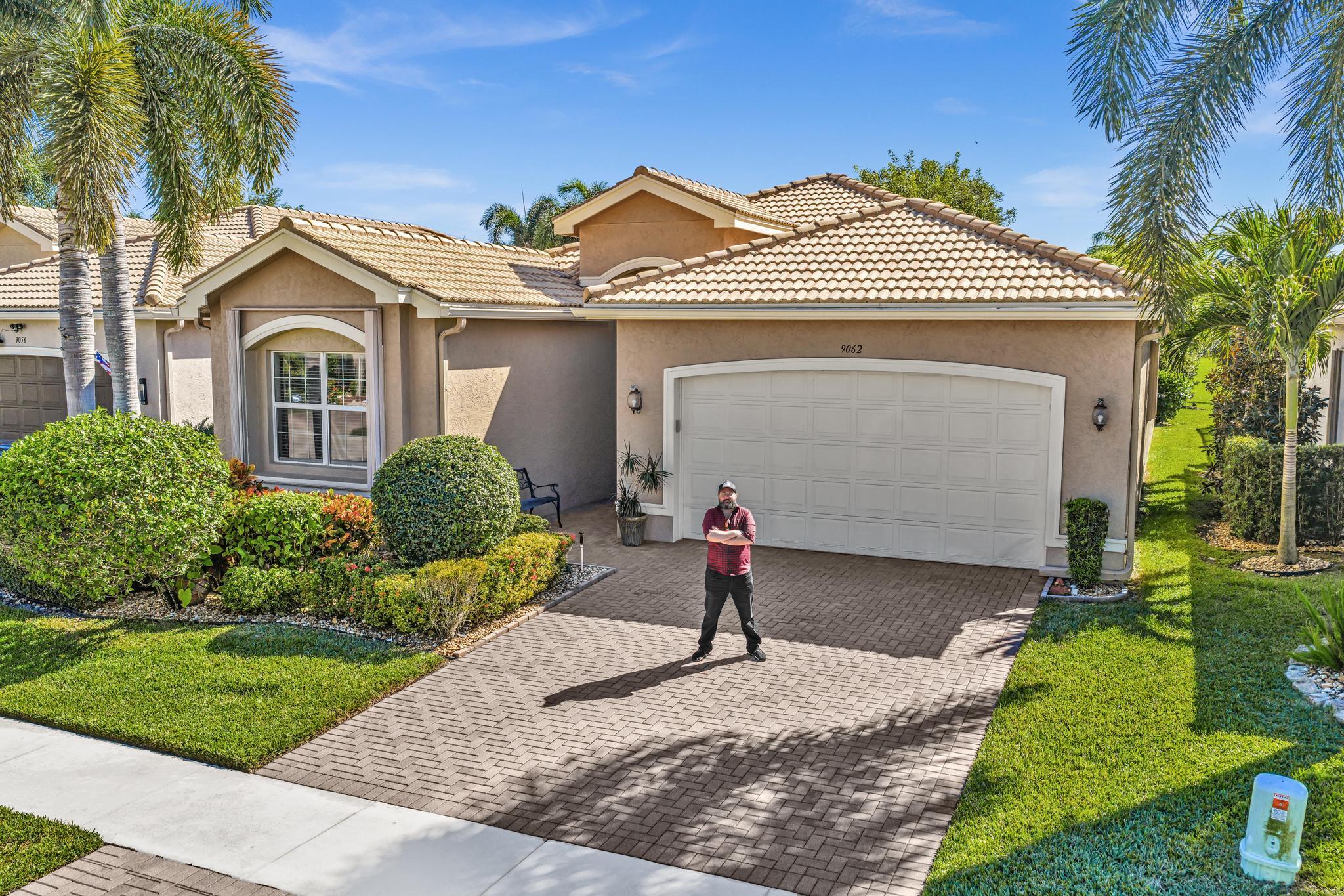 9062 Meridian View Isle Boynton Beach, FL 33473 - Photo 57 of 71 a front view of a house with a yard and garage