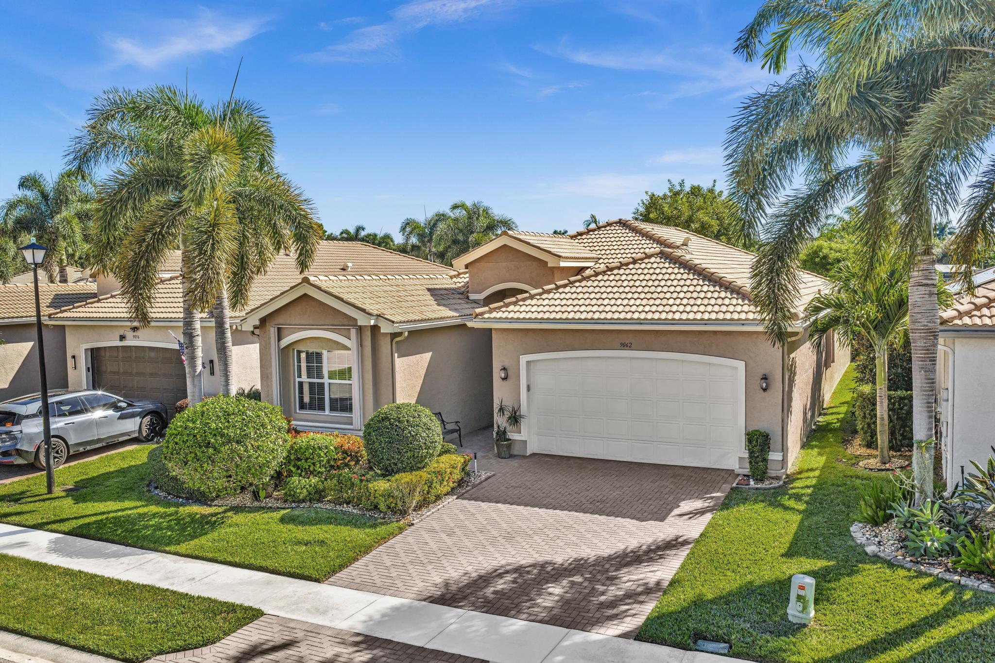 9062 Meridian View Isle Boynton Beach, FL 33473 - Photo 70 of 71 a front view of a house with a garden and plants