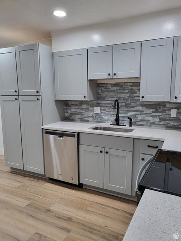 6884 670 East Midvale, UT 84047 - Photo 4 of 28 Kitchen featuring gray cabinets, black range with electric cooktop, dishwasher, light stone counters, and light wood-style flooring