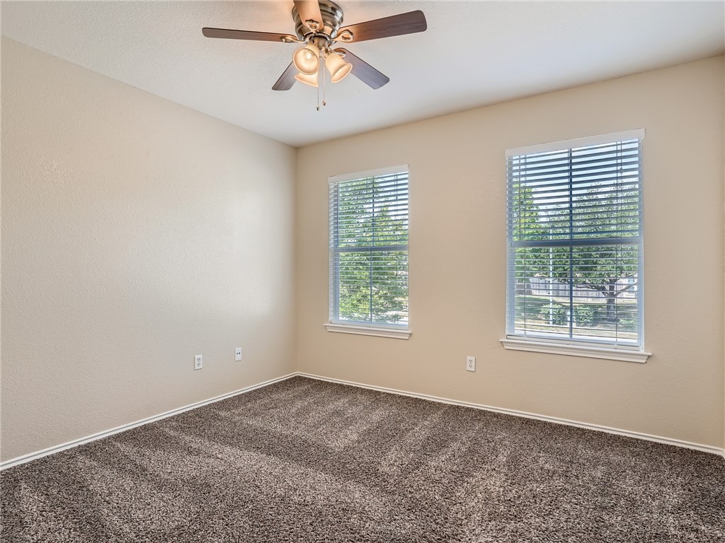 13913 Harris Ridge Boulevard, Unit B Pflugerville, TX 78660 - Photo 19 of 25 an empty room with a window and a fan