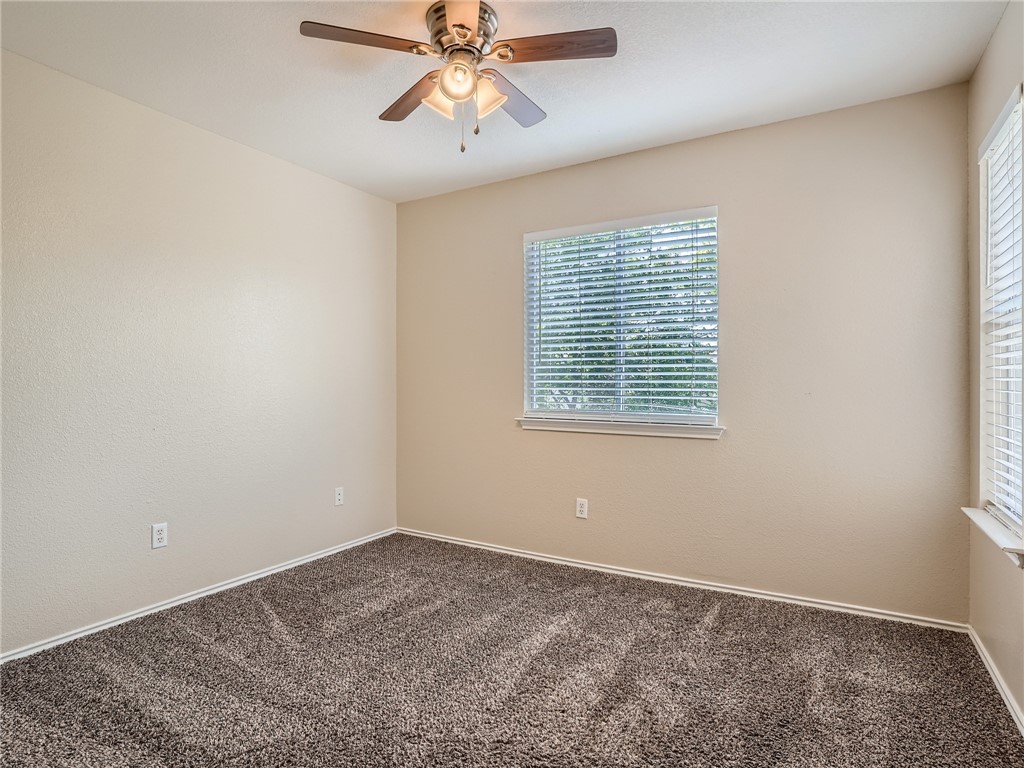 13913 Harris Ridge Boulevard, Unit B Pflugerville, TX 78660 - Photo 20 of 25 an empty room with windows and fan