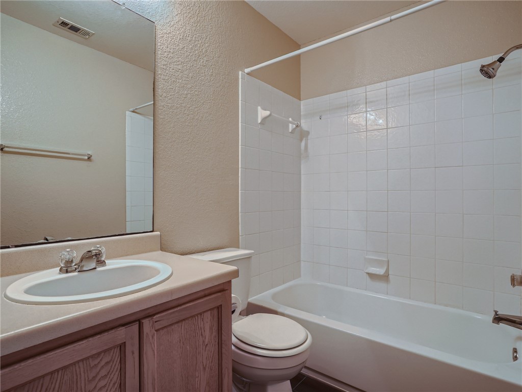 13913 Harris Ridge Boulevard, Unit B Pflugerville, TX 78660 - Photo 21 of 25 a bathroom with a granite countertop sink toilet a mirror and shower