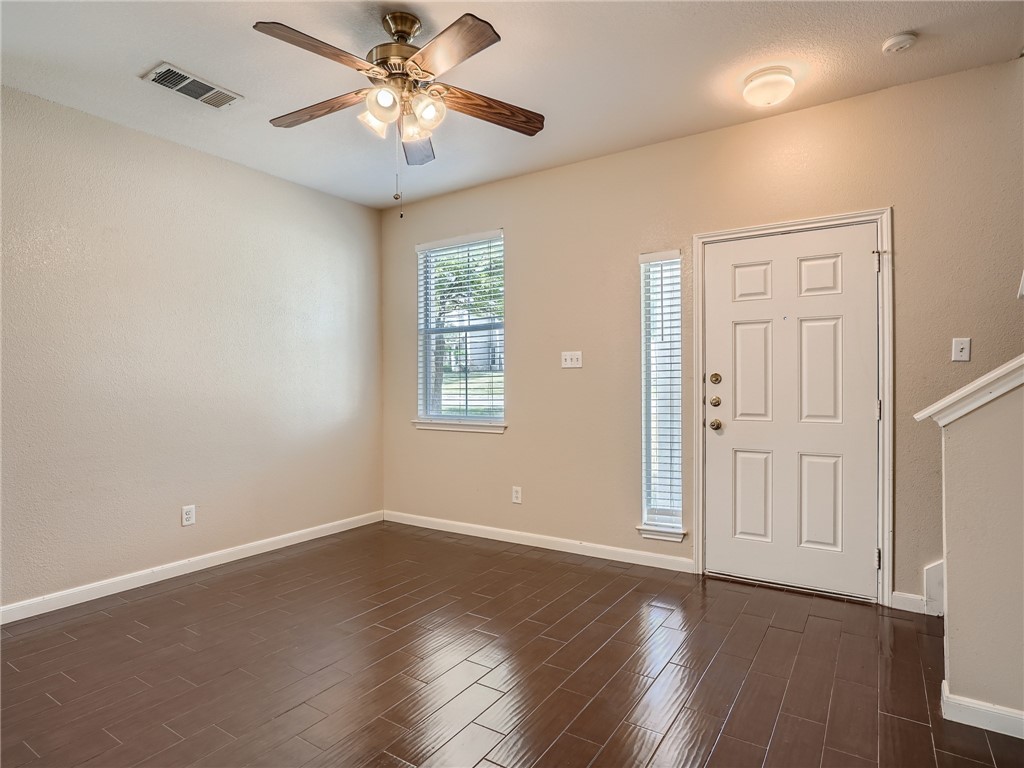 13913 Harris Ridge Boulevard, Unit B Pflugerville, TX 78660 - Photo 5 of 25 a view of a livingroom with a fan a ceiling fan and wooden floor