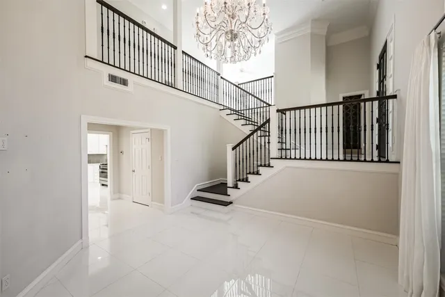 a view of staircase with lots of frames on wall and a window