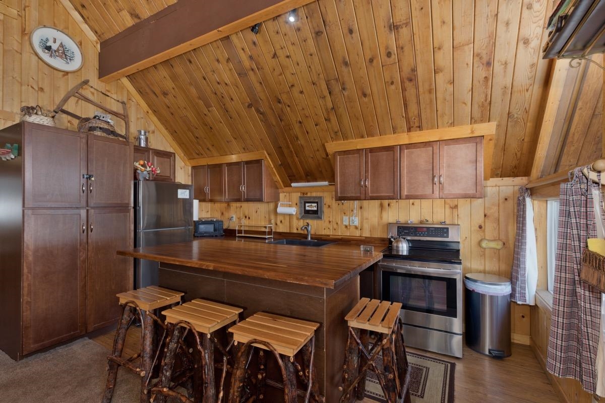 11000 Minaret Road, Unit 2 Mammoth Lakes, CA 93546 - Photo 17 of 31 a kitchen with stainless steel appliances a stove a refrigerator and cabinets