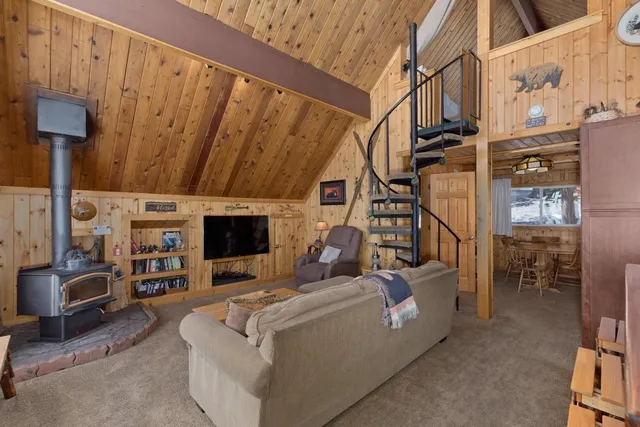 a living room with furniture a flat screen tv and a floor to ceiling window
