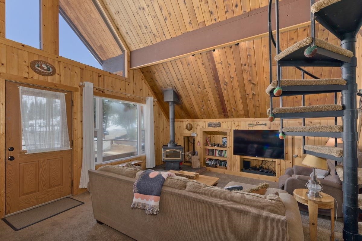 11000 Minaret Road, Unit 2 Mammoth Lakes, CA 93546 - Photo 9 of 31 a living room with furniture a flat screen tv and a floor to ceiling window