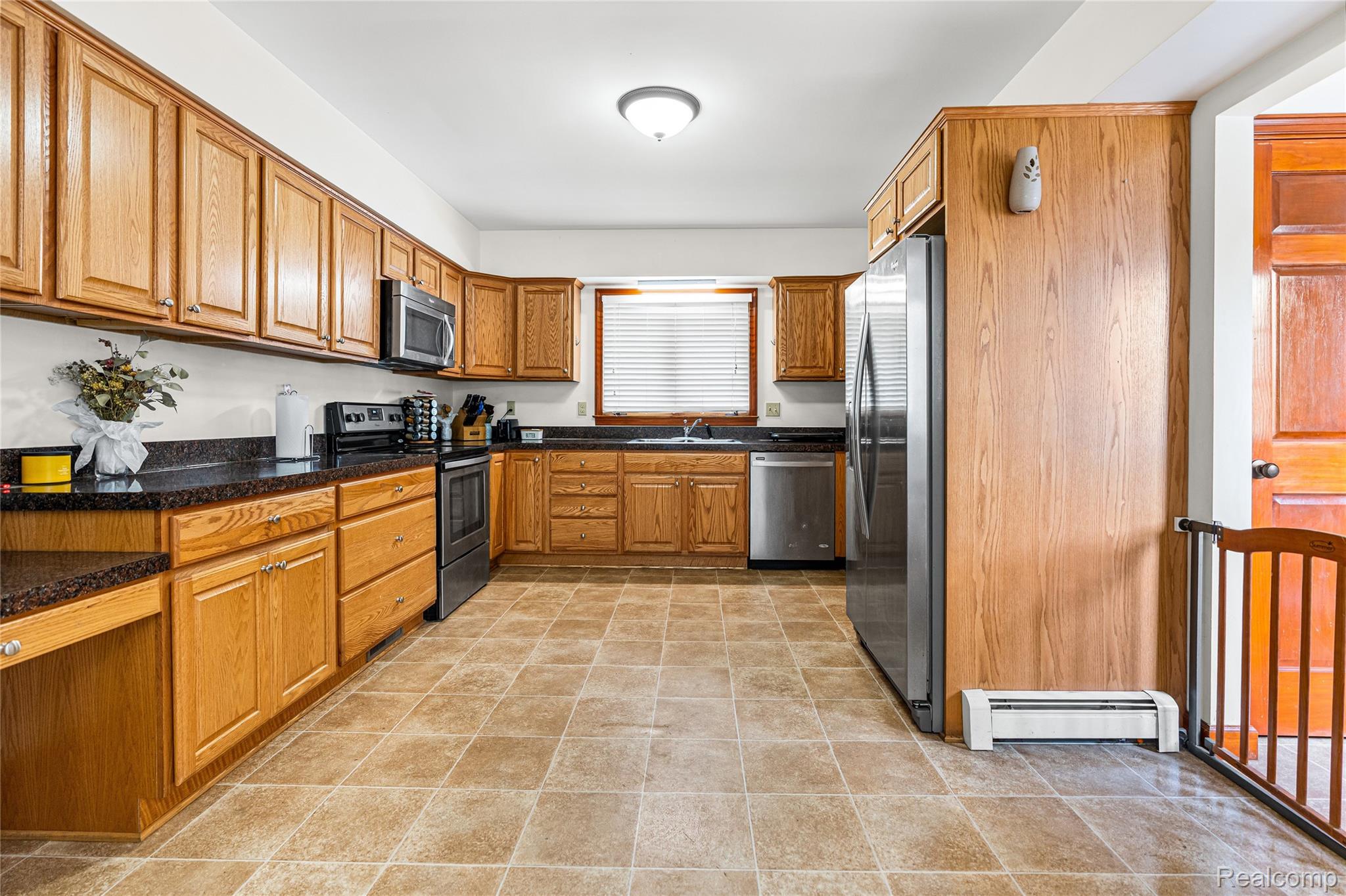 6383 Lapeer Road Burton, MI 48509 - Photo 9 of 44 Kitchen with wood finish cabinetry, stainless steel appliances, and baseboard heating