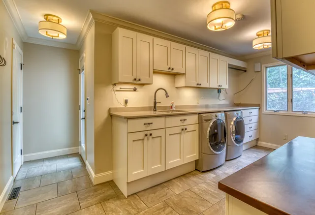 a kitchen with a sink a stove and cabinets