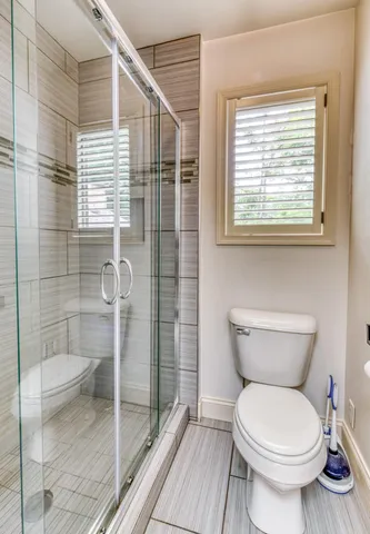 a bathroom with a toilet and a shower