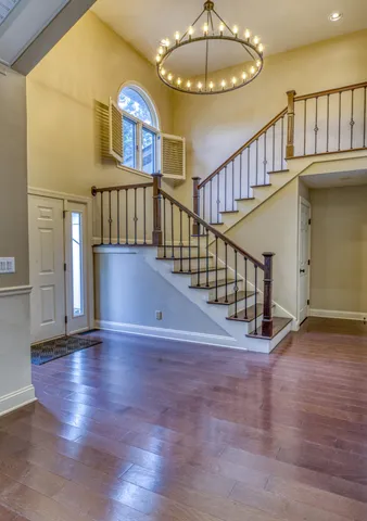 a view of staircase with wooden floor and a chandelier