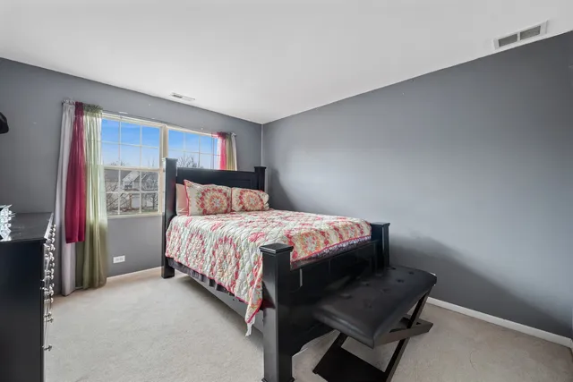 a bedroom with a bed chair and a window