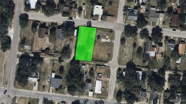 a view of a field with trees in the background