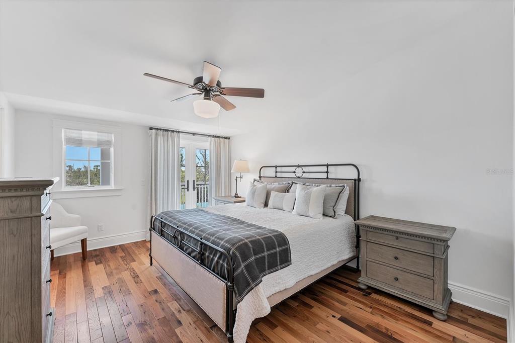 150 1st Street East Boca Grande, FL 33921 - Photo 34 of 72 a bedroom with a bed and a table with wooden floor