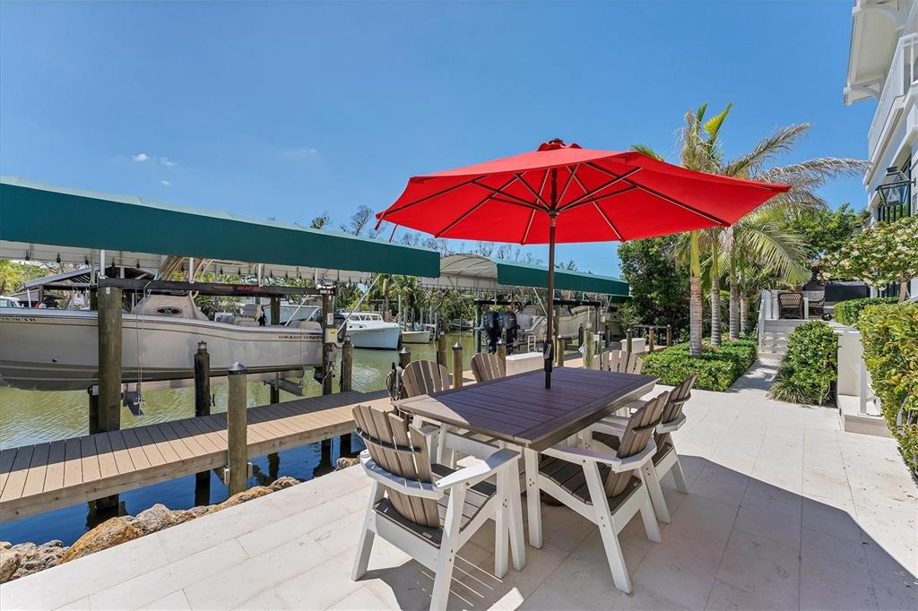 150 1st Street East Boca Grande, FL 33921 - Photo 50 of 72 a view of a patio with a table and chairs under an umbrella