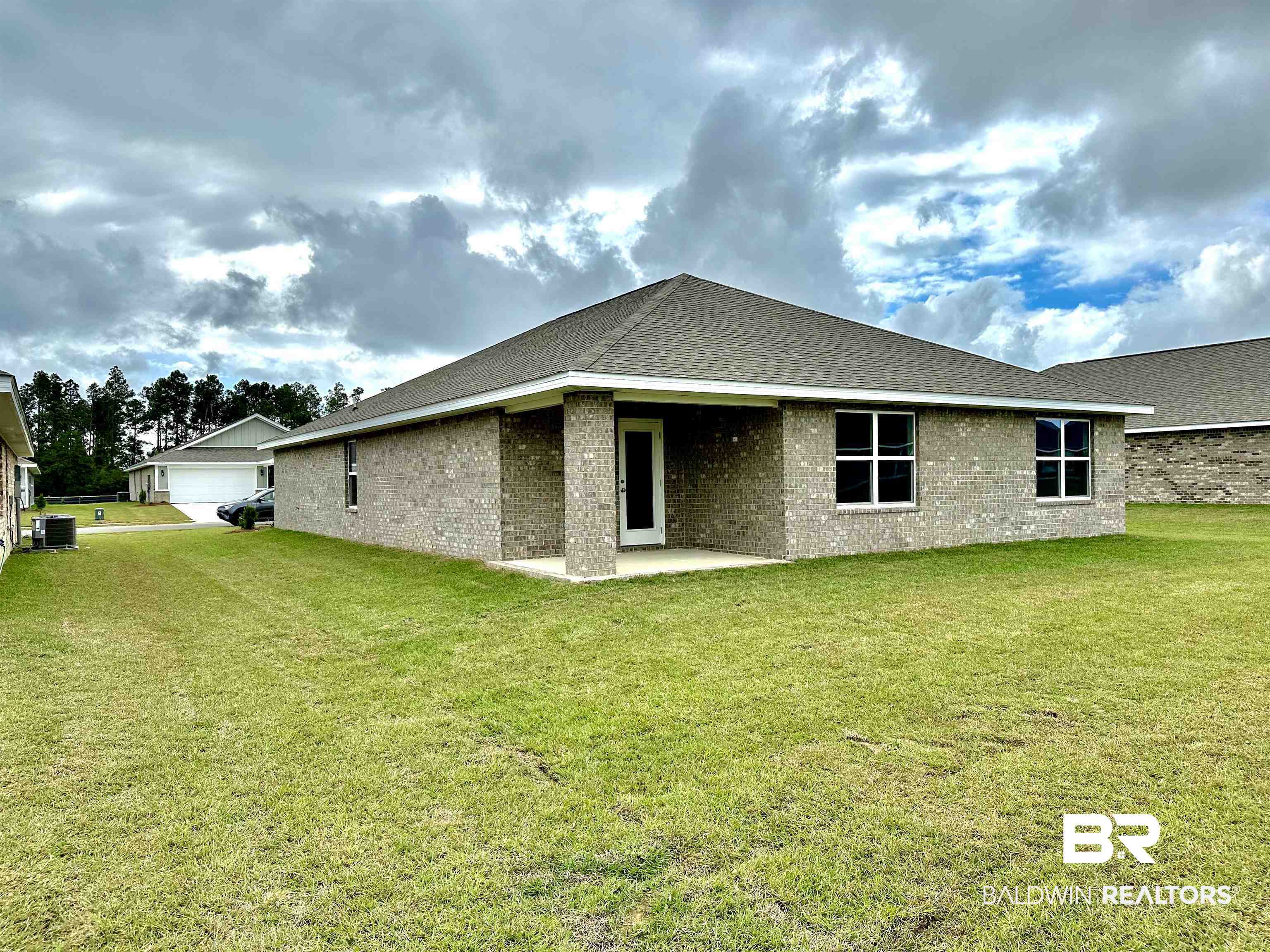 1238 Hayward Loop Foley, AL 36535 - Photo 6 of 46 Back of property with central AC unit, a patio area, and a yard