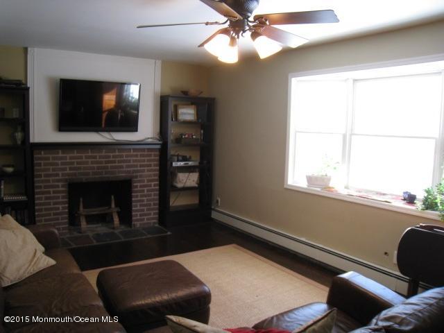 67 Aberdeen Road Matawan, NJ 07747 - Photo 9 of 17 a living room with furniture a flat screen tv and a fireplace