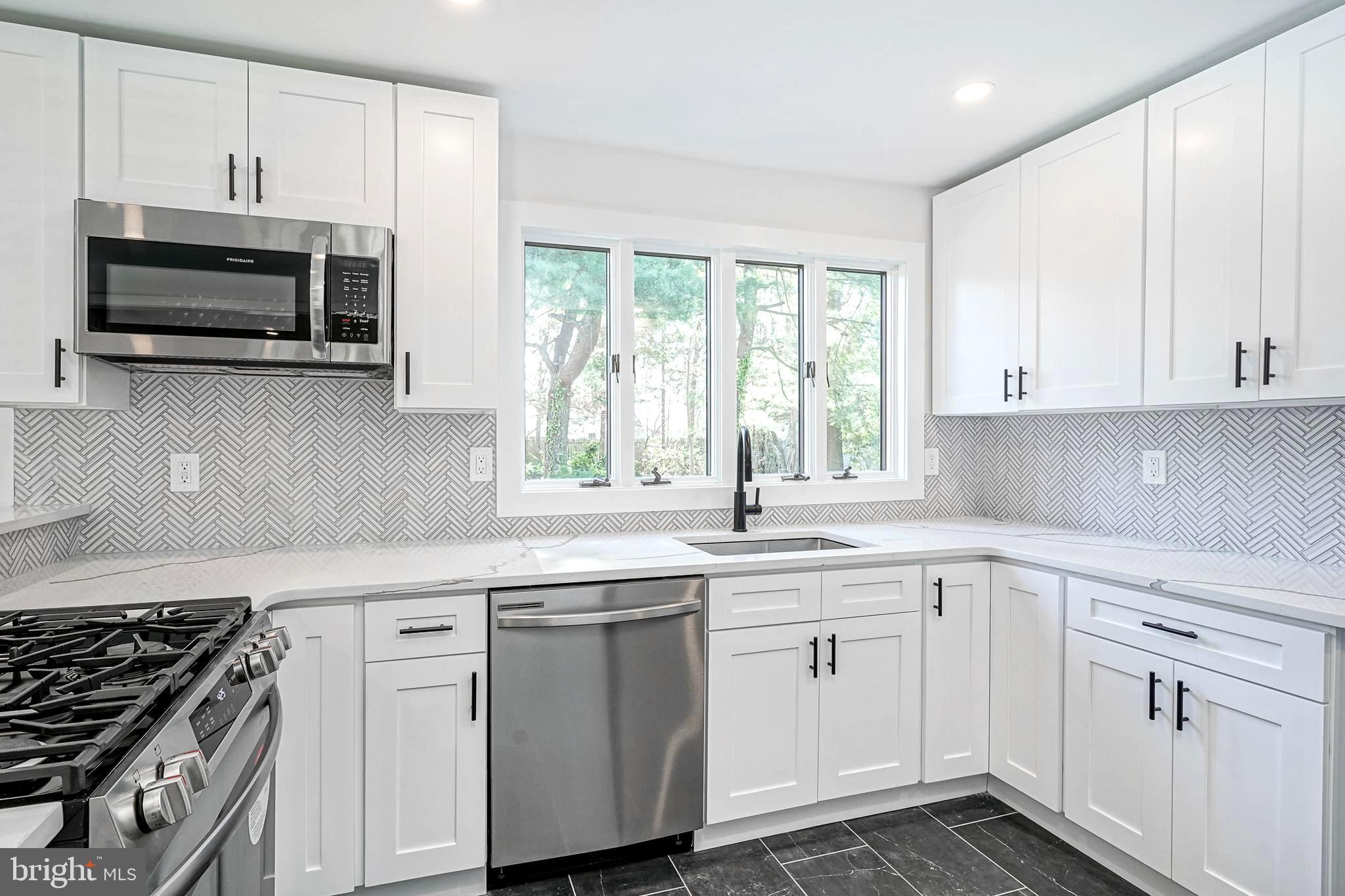 511 Boundary Road Pitman, NJ 08071 - Photo 12 of 36 a kitchen with cabinets appliances a sink and a window