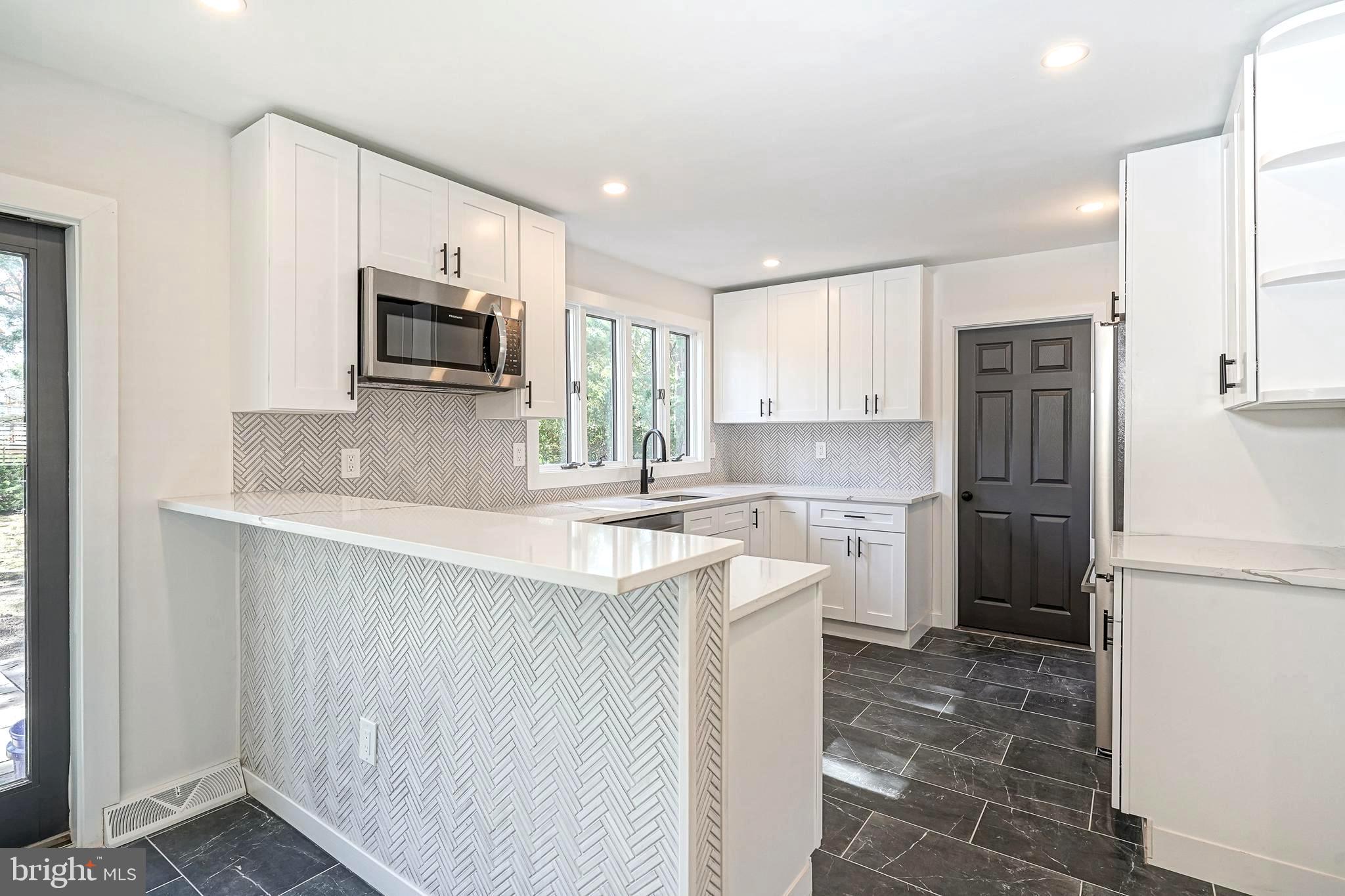 511 Boundary Road Pitman, NJ 08071 - Photo 9 of 36 a kitchen with a sink a microwave a refrigerator and cabinets