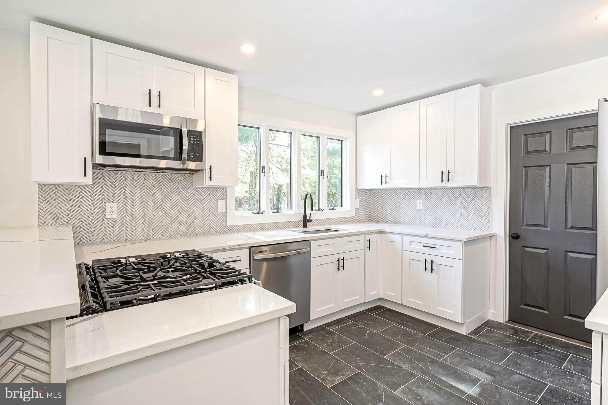 511 Boundary Road Pitman, NJ 08071 - Photo 10 of 36 a kitchen with stainless steel appliances granite countertop a stove a sink and a microwave