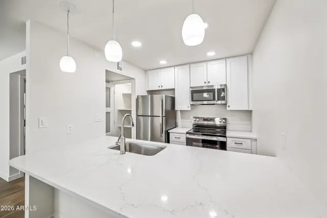 a kitchen with stainless steel appliances granite countertop a stove microwave and refrigerator